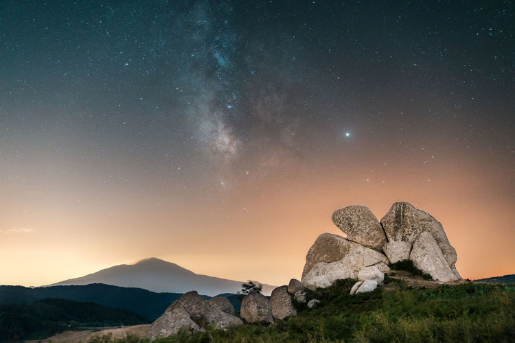 Scenic view of rock against sky at night