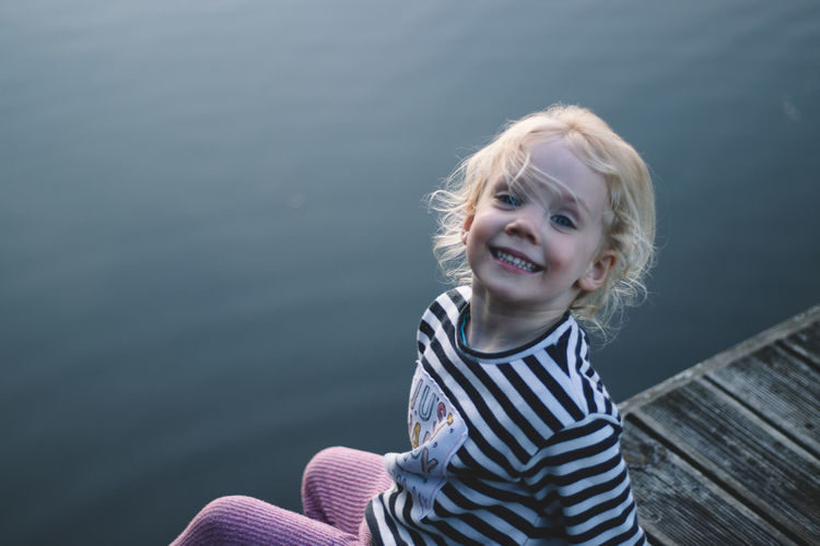 Portrait of smiling girl against water