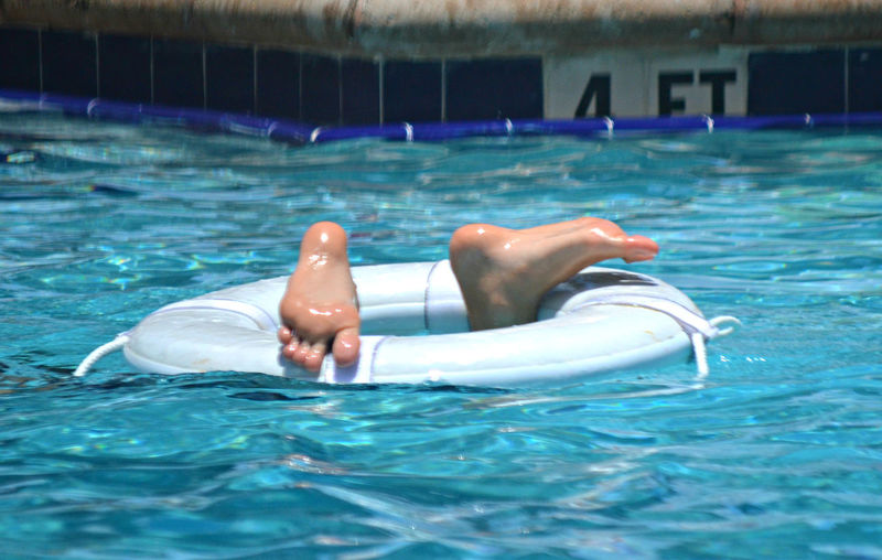 View of feet poking out of swimming pool