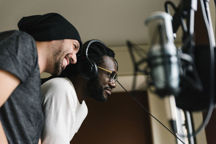 Men listening music while standing in studio
