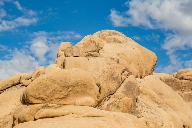 Large rock formations in joshua tree national park, with a blue sky overhead