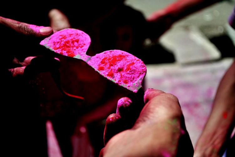 Cropped image of man holding pink powdered sunglasses