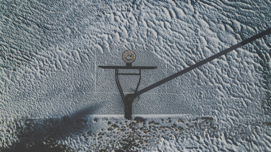 Aerial view of snow covers the land with a dark shadow over the court