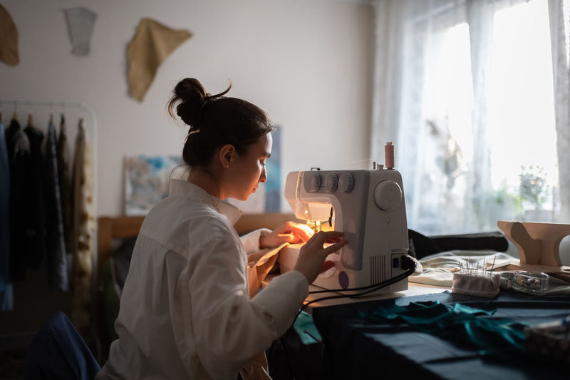 Young seamstress working at home