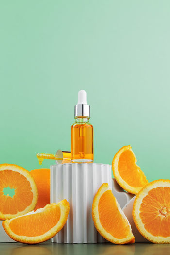Close-up of orange bottle against blue background