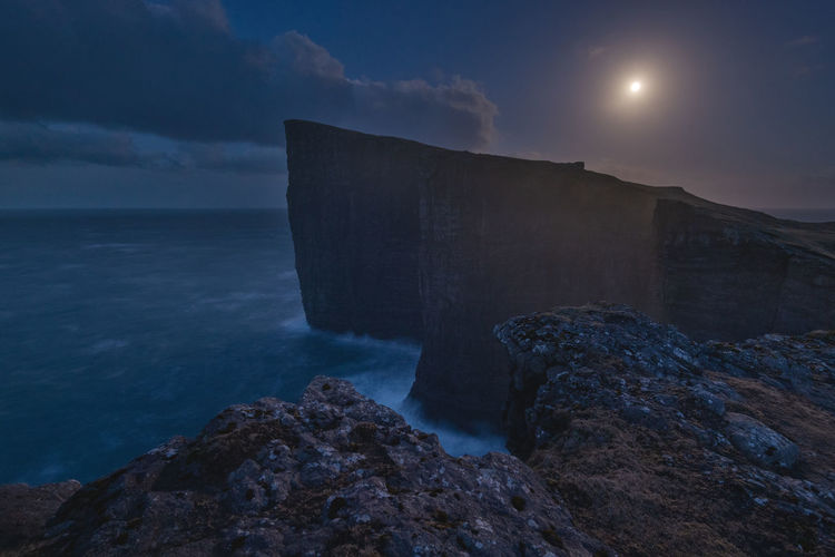 Rock formation in sea against sky