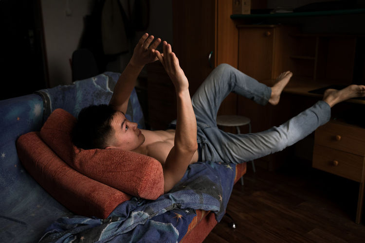 Man lying on bed at home