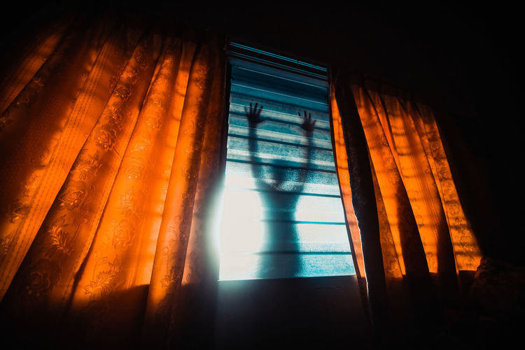 LOW ANGLE VIEW OF SUNLIGHT STREAMING THROUGH GLASS WINDOW