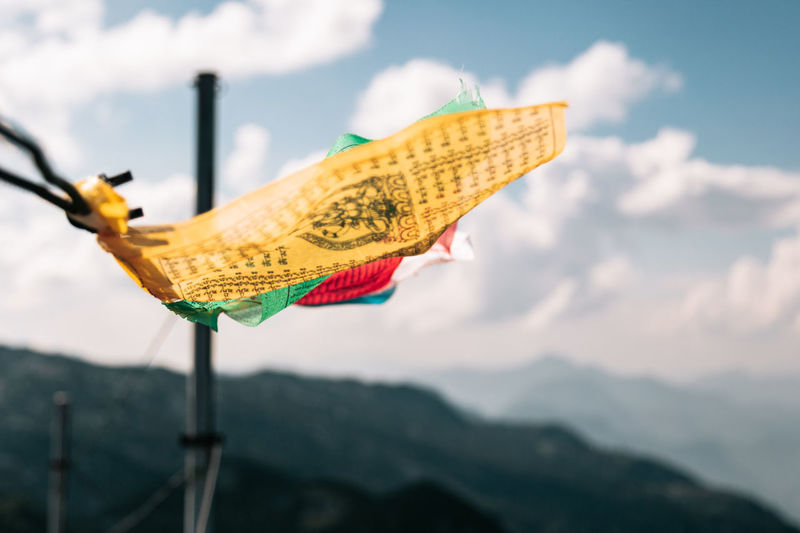 Close-up of yellow flag on land against sky