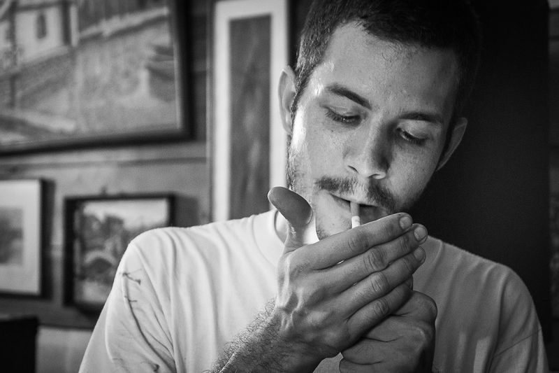 Man smoking cigarette at home