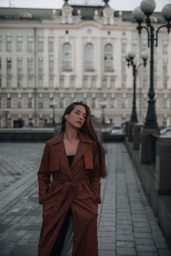 Autumn fashionable female outfit. stylish woman walking in brown coat outdoors. trendy 