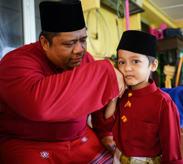 Father and son in traditional clothing at home