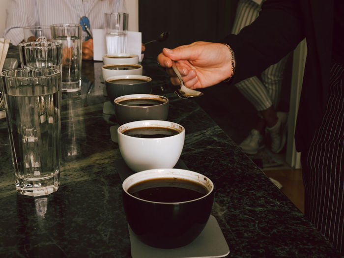Hand holding coffee cup, coffee cupping
