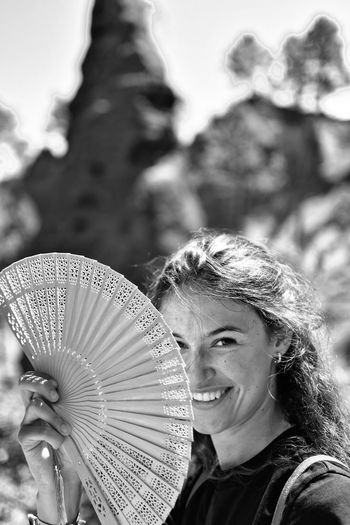 Portrait of smiling woman holding hand fan