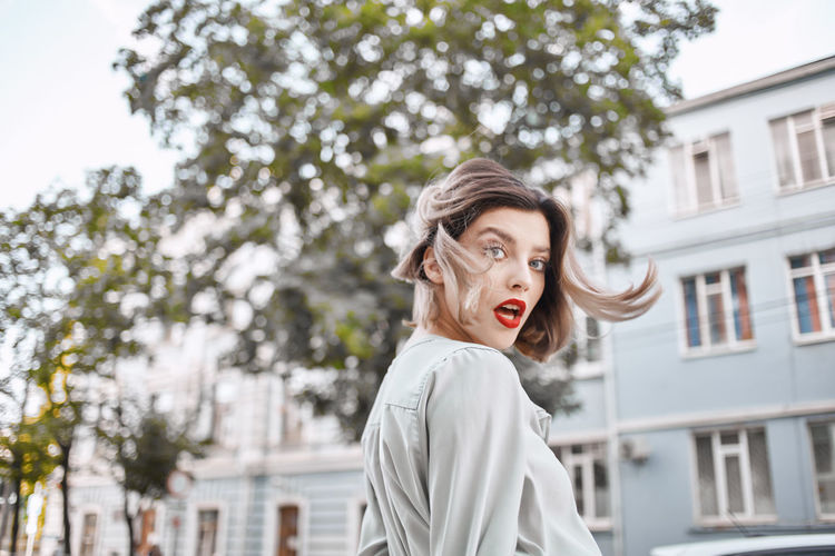Portrait of woman wearing sunglasses against trees