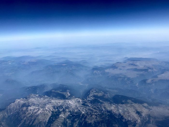 Aerial view of mountains against blue sky