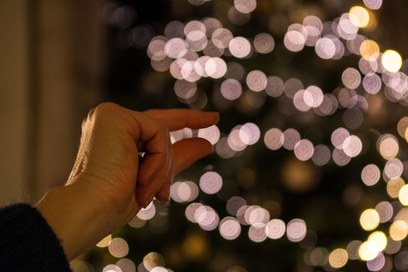 Cropped hand of woman holding illuminated lights