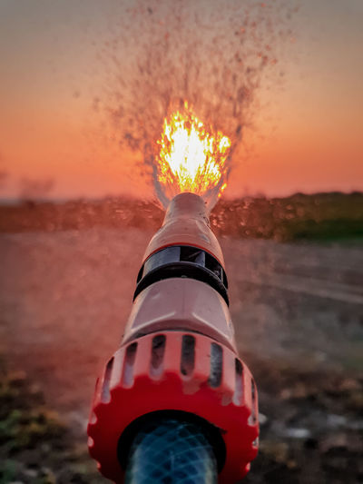 Close-up of fire hydrant against sky during sunset