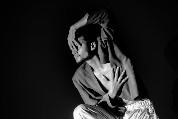 Rear view of woman standing against black background