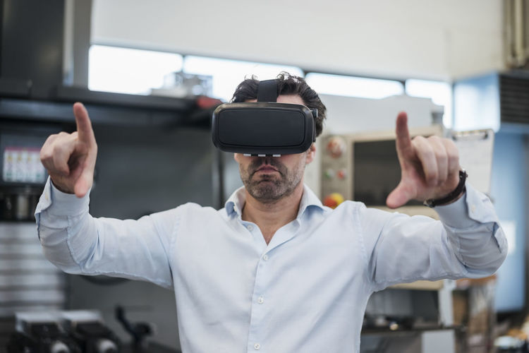 Businessman using vr glasses in a factory