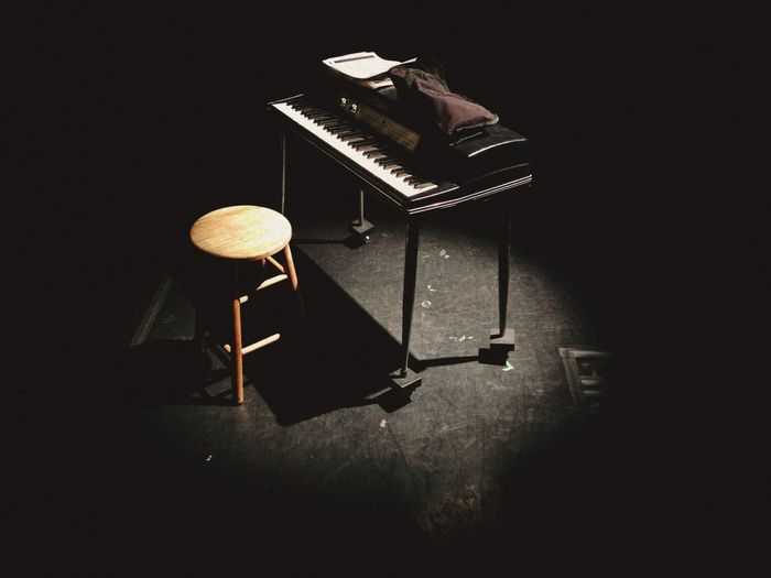 Piano and stool in dark room