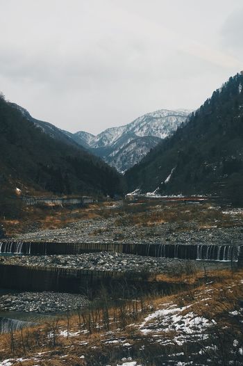 Scenic view of lake by mountains against sky