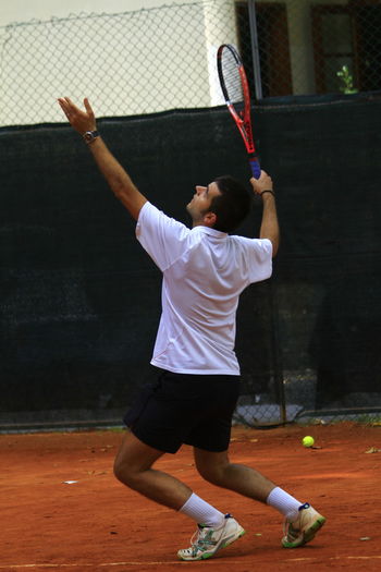 Man playing tennis in court