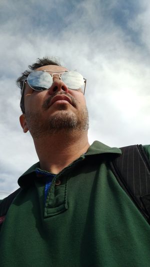 Low angle view of man wearing sunglasses against sky