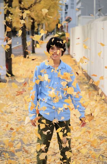 Portrait of boy standing in leaves