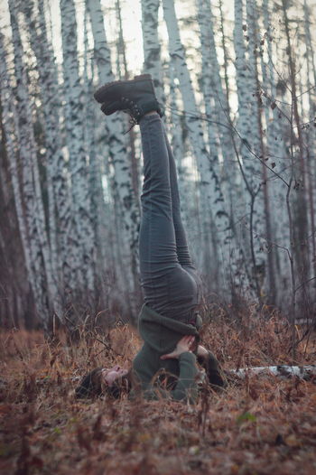 Woman exercising on field in forest