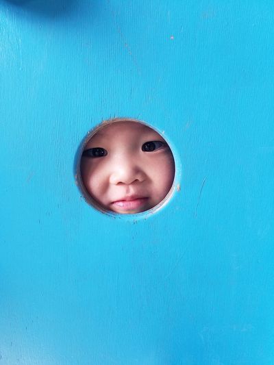 Portrait of cute boy seen through hole