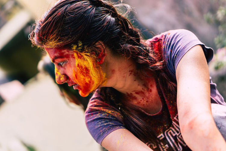 Young woman with powder paint on face during holi