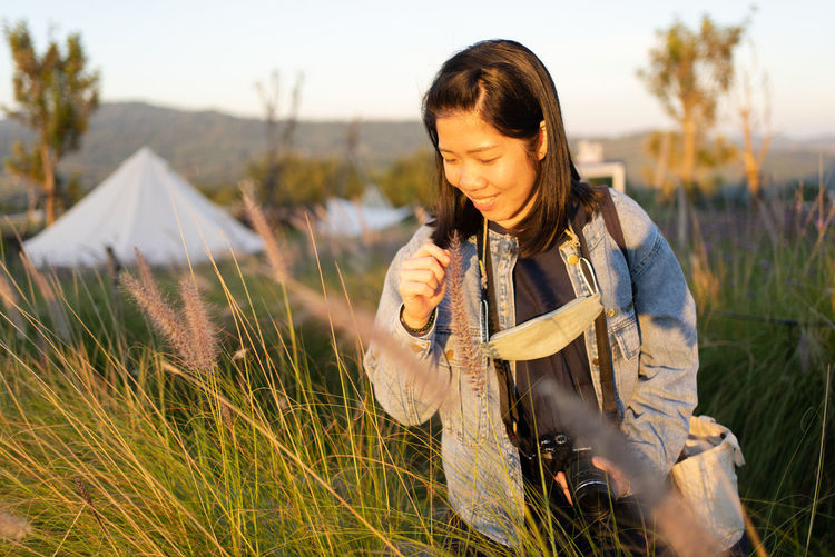 Portrait of young woman standing on field