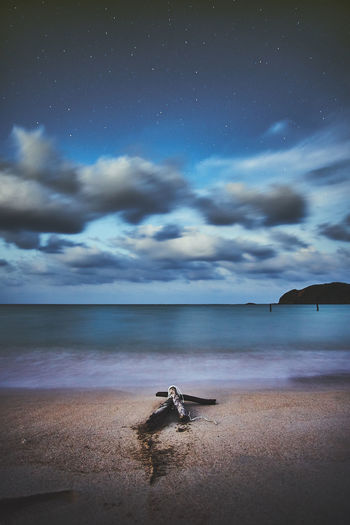 Scenic view of beach against cloudy sky at night