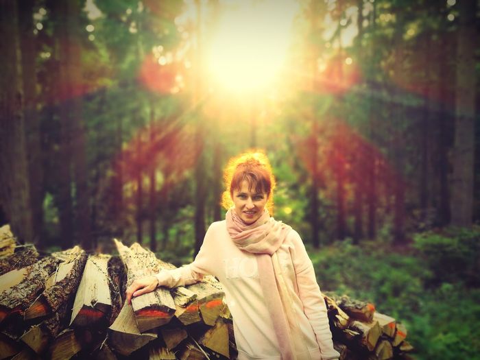 Portrait of woman in forest during sunset