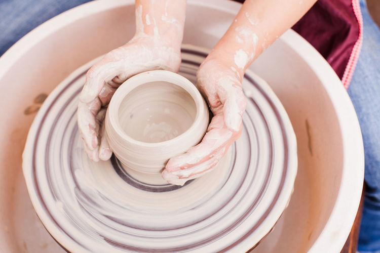 Cropped hand of girl making pottery