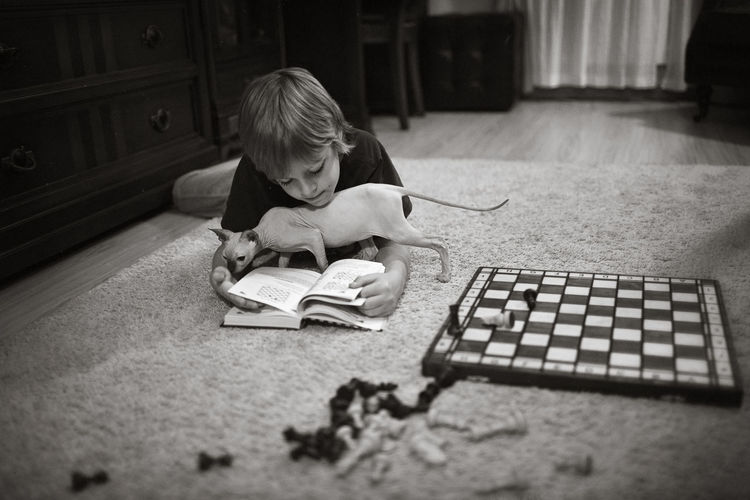 Boy playing with book on floor