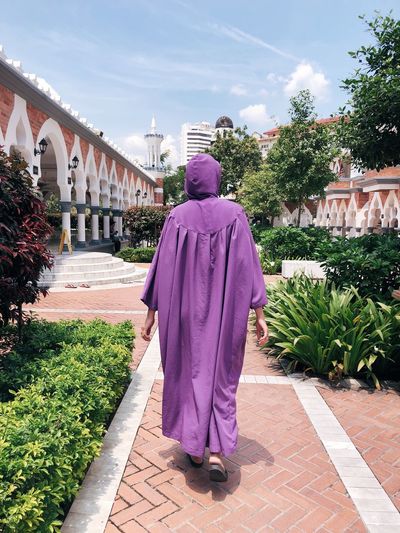 Rear view of women walking on footpath