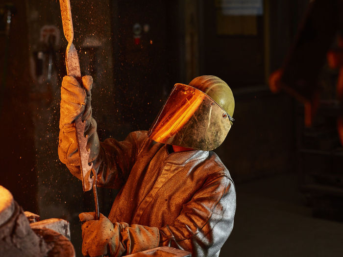 Industry, worker at furnace during melting copper, wearing a fire proximity suit