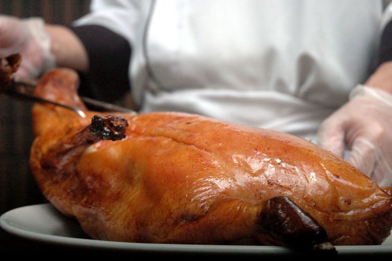 Close-up of hand carving roast goose meat