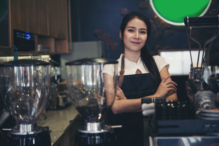Portrait of smiling woman standing in cafe
