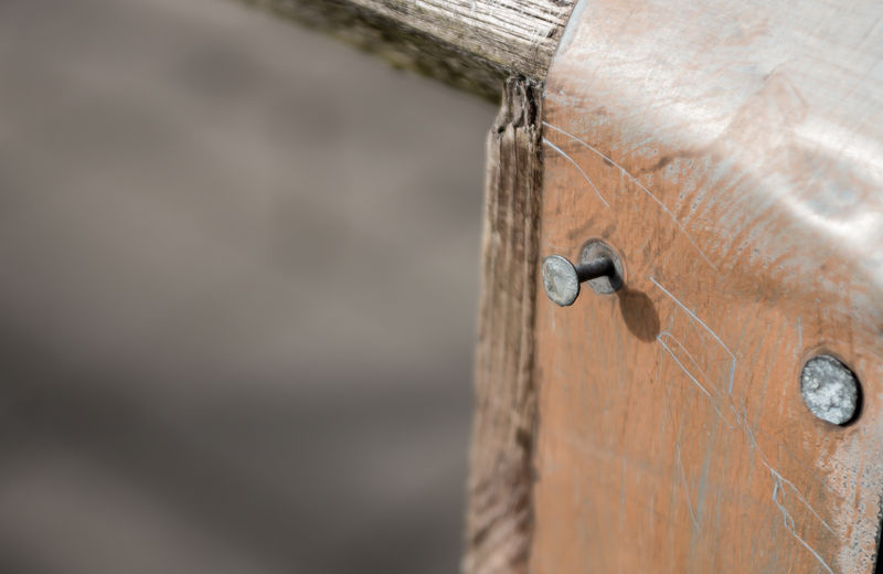 Two small nails hammered into a piece of leather fixed to a wooden frame