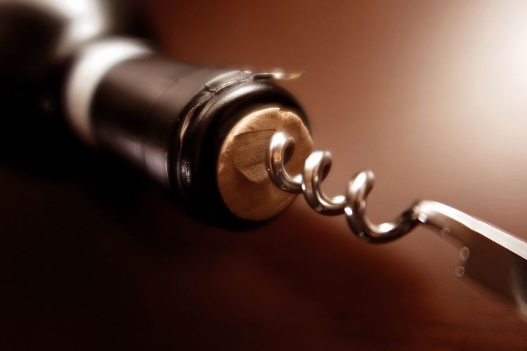 Close-up of corkscrew and wine bottle