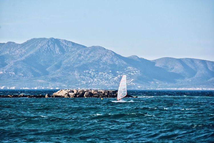 Windsurfing board on sea against mountains