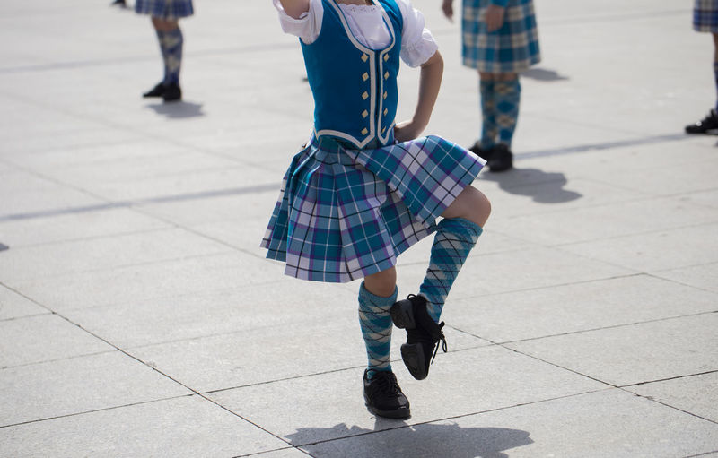 Low section of girl dancing on footpath