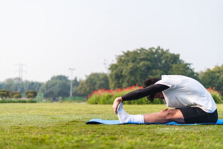 Side view of woman exercising on field