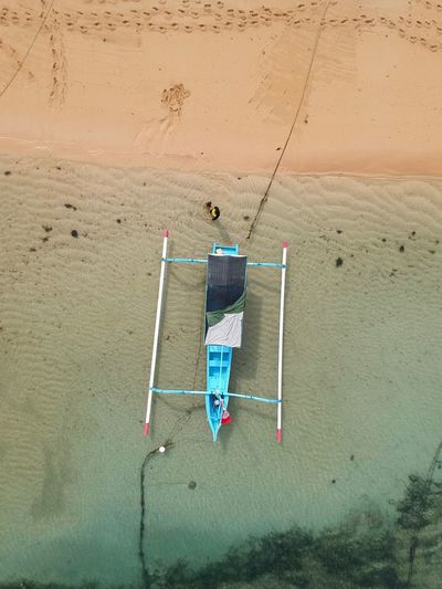 Directly above shot of boat moored at beach 