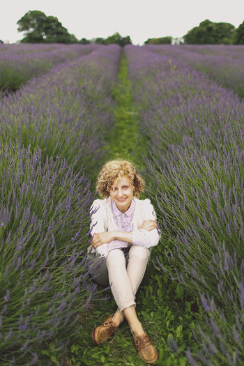 Portrait of woman sitting in lavender field