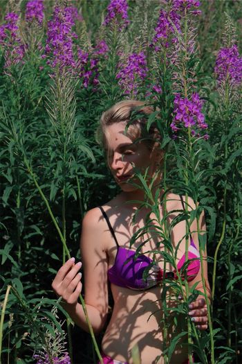 Woman in bikini standing amidst plants
