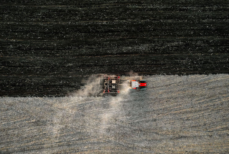 Aerial view of tractor ploughing agricultural field in autumn